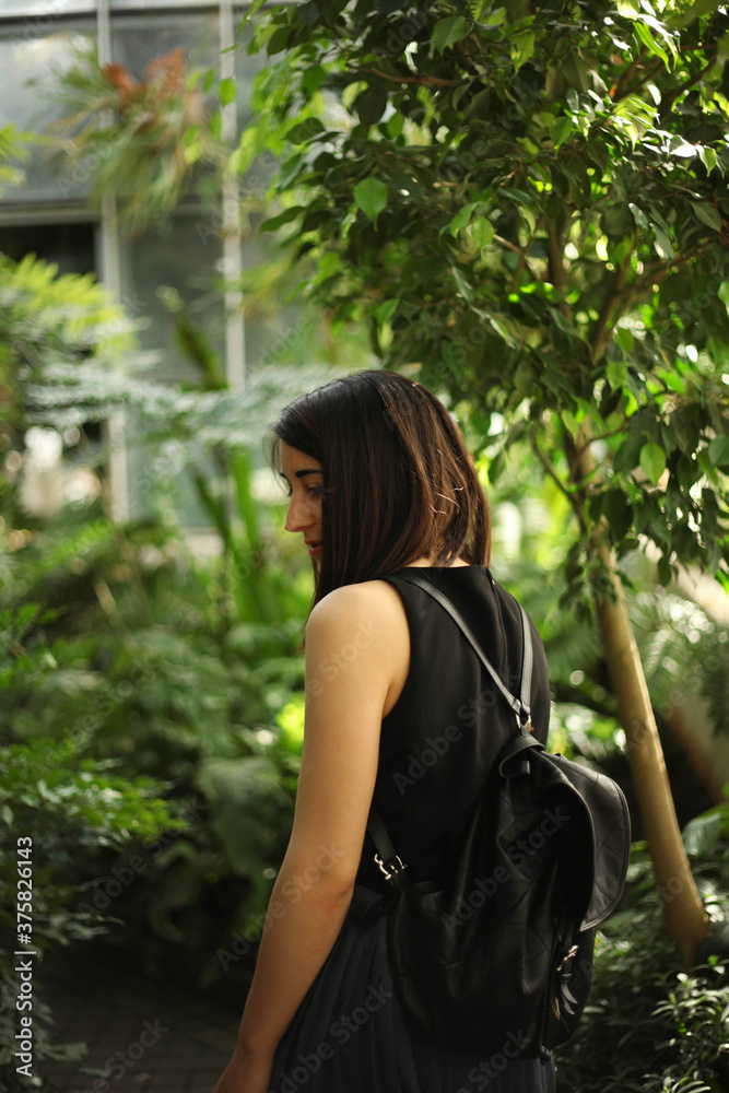 Woman looking at plants in a botanical garden. From behind. Woman looking at plants in a botanical garden. From behind.