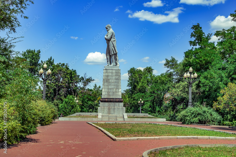 Dnipro, Ukraine - July 21, 2020: Side view of the monument to Taras Shevchenko on Monastyrsky Island in Dnipro. Sculpture of the famous Ukrainian poet Kobzar in the summer park - obrazy, fototapety, plakaty 