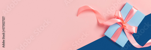 Greeting web banner with blue gift box. Pink bows. Space for your text. photo