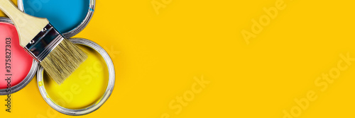 Renovation concept. Yellow web banner with three color paint jars and one brush. 
