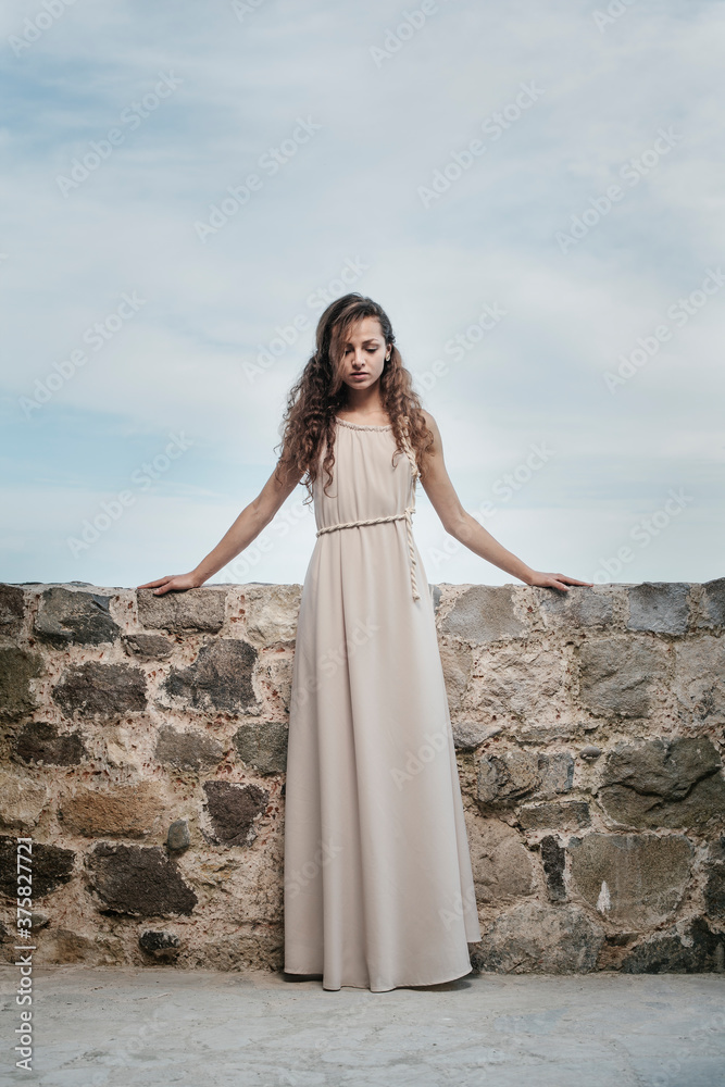 Beautiful woman with a nice dress posing by the sea Beautiful woman with a nice dress posing by the sea