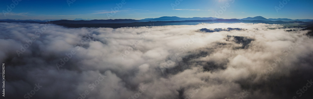 Early morning drone panorama of Planinsko Polje field in Slovenia during thick fog over the plain, with only higher hills such as Slivnica are seen sticking out. Early morning drone panorama of Planinsko Polje field in Slovenia during thick fog over the plain, with only higher hills such as Slivnica are seen sticking out.