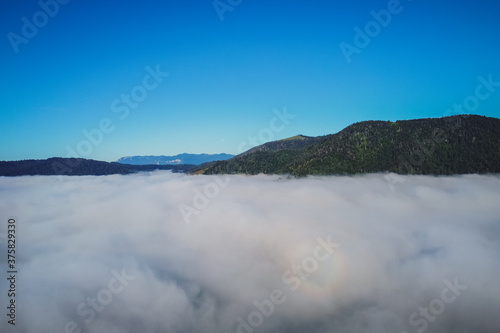 Early morning drone panorama of Planinsko Polje field in Slovenia during thick fog over the plain, with only higher hills such as Strmca are seen sticking out.