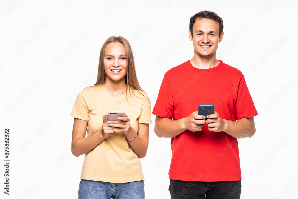 Happy couple looking at smartphone on gray background Happy couple looking at smartphone on gray background