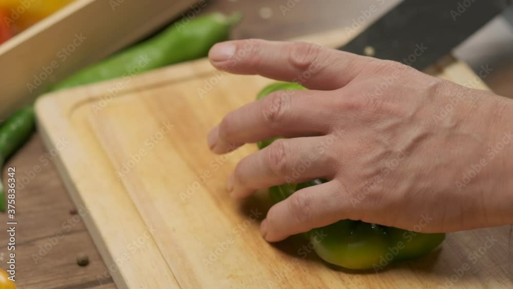 Professional chef prepares and cuts green bell pepper. Close up slow motion Professional chef prepares and cuts green bell pepper. Close up slow motion