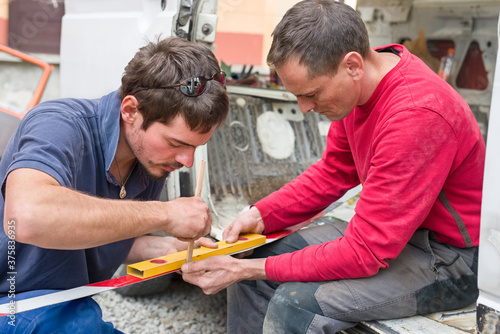 Two male workers making measurements for a restoration process photo