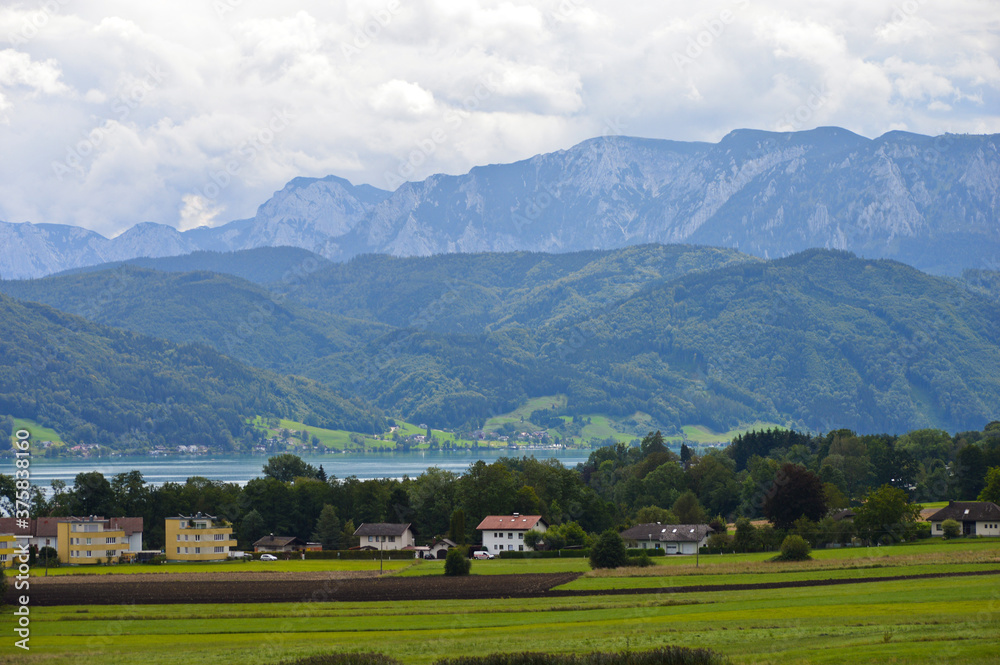 Austrian rural area beside the Attersee lake with mountains in the background Austrian rural area beside the Attersee lake with mountains in the background