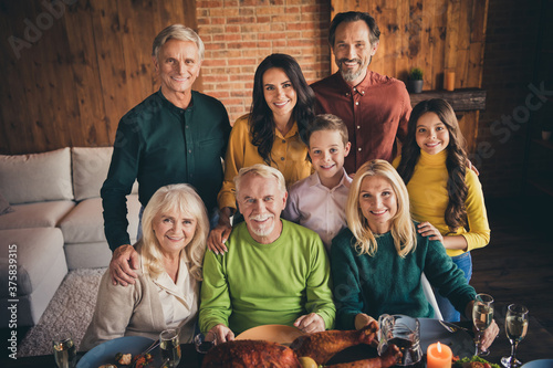 Portrait of nice attractive cheerful adorable family grandparents parents meeting spending festal day luncheon autumn celebration embracing at modern loft brick industrial interior