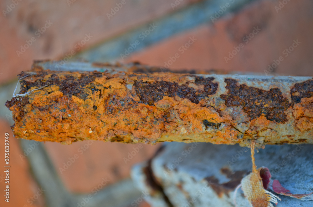 Fototapeta premium a piece of old square pipe overgrown with red rust