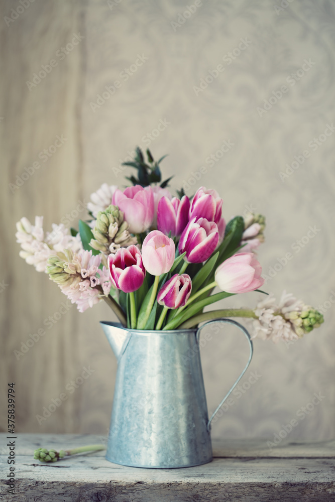 Spring flowers in a tin jug Spring flowers in a tin jug