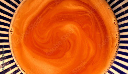 Surface of a cup with creamy coffee foam in brown tones photo