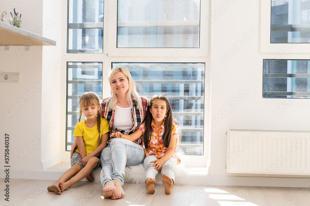 Woman and two young girls playing and smiling Woman and two young girls playing and smiling