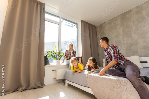 A happy family on white bed in the bedroom