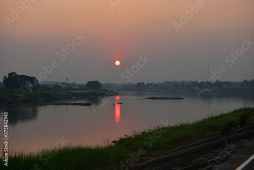 Sunset at the Chao Phraya River at Dechatiwong Bridge, Nakhon Sawan city Thailand. photo