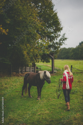 Horsewoman preparing for riding in field photo