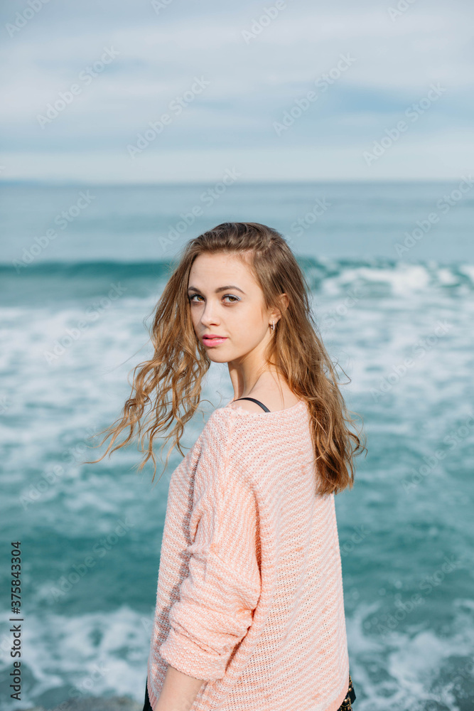 Portrait of woman looking at camera with sea in the background