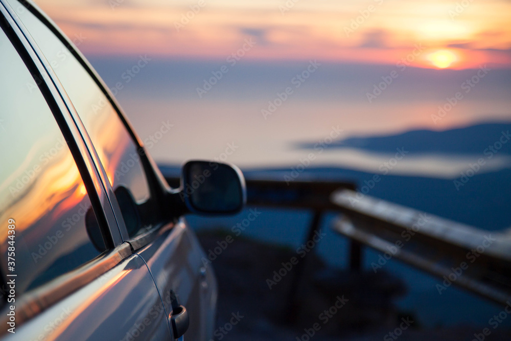 Road trip by car at sunset. Parking on roadside of narrow mountain way. Stop for rest. View of amazing sea coastline. Concept of outdoor adventure, summer vacation. Copy space