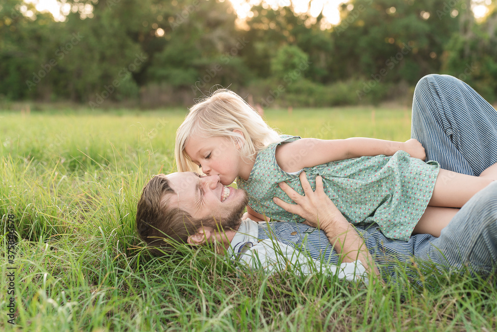 A Little Girl Kisses Her Father On The Ground A Little Girl Kisses Her Father On The Ground