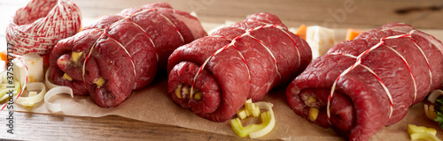 Prepared raw beef roulades with pickle and bacon