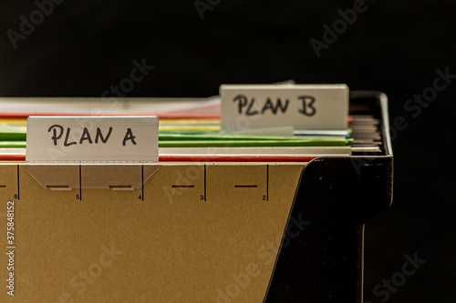 Closeup of plastic file holder with files labeled Plan A and Plan B photo