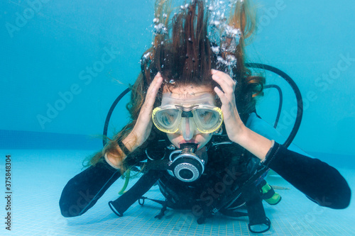 Woman scuba diving holding her head as if having ear equalization problem