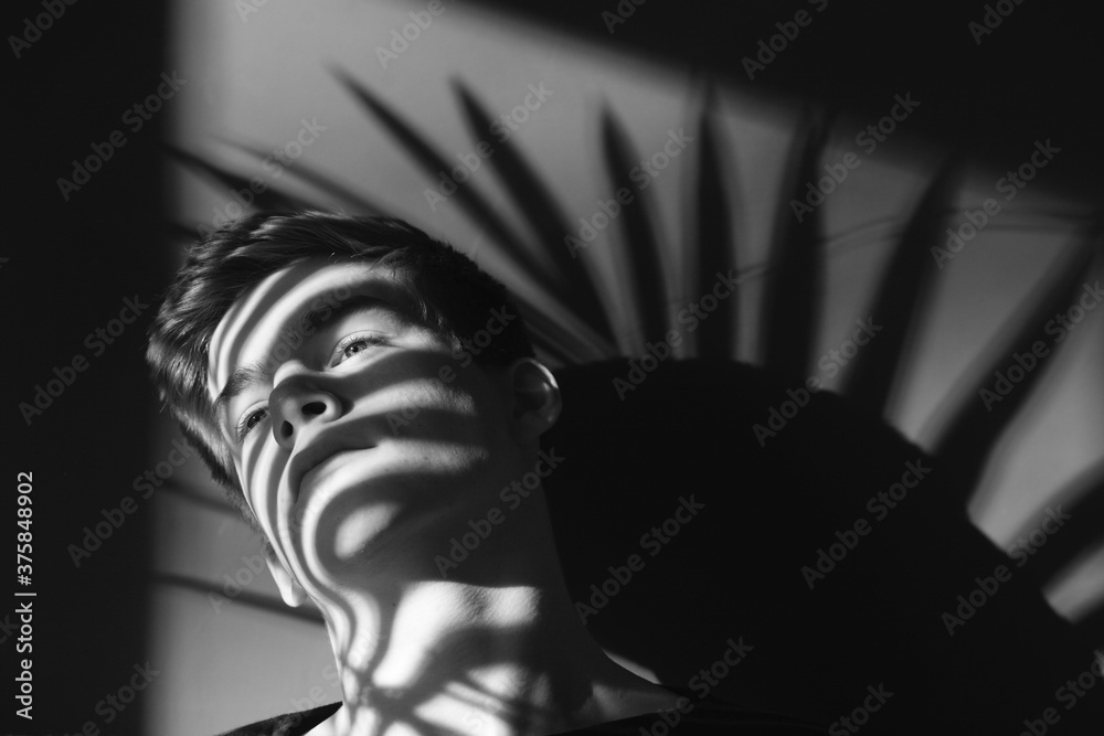 © Marcel/Stocksy - Young man and the shadow of a leaf