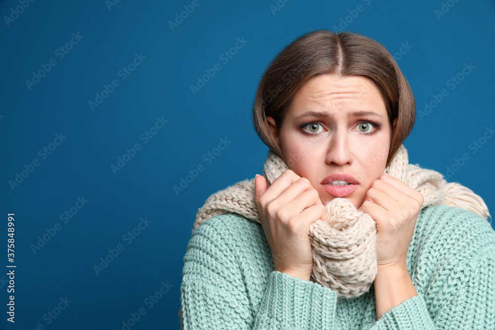 Young woman wearing scarf suffering from fever on blue background, space for text. Cold symptoms Young woman wearing scarf suffering from fever on blue background, space for text. Cold symptoms