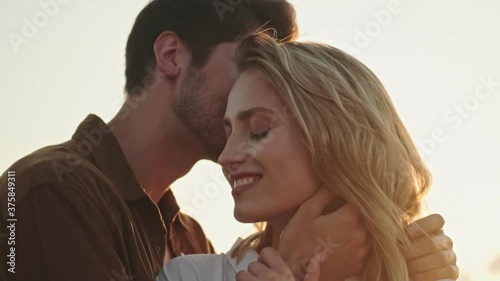 Close-up view of a young attractive couple in love man and woman are hugging while dating walking in the field photo