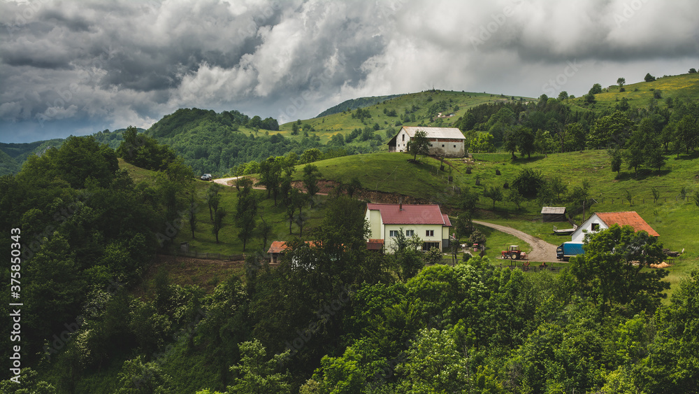 Small farm in a mountain village under the cloudy sky in western Serbia