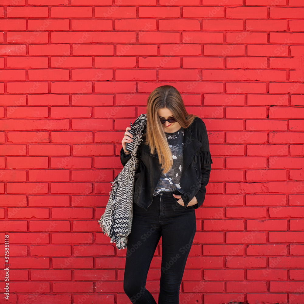 Young woman in front of a red brick wall Young woman in front of a red brick wall