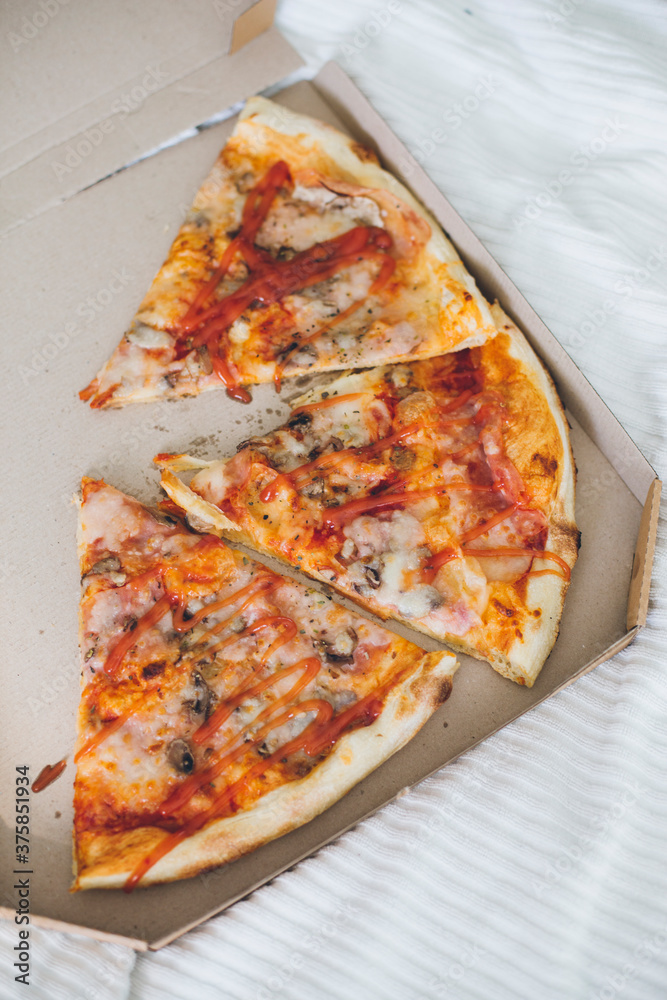 Pizza slices in the box on a bed Pizza slices in the box on a bed