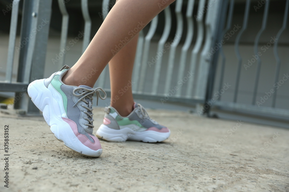 woman legs in sneakers outdoor close up