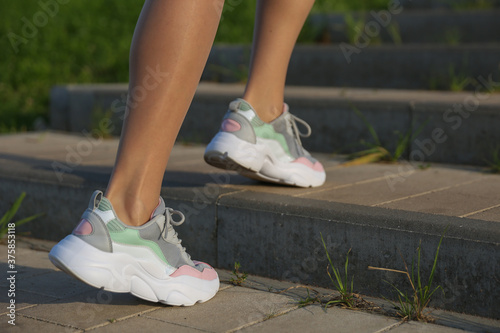 woman legs in sneakers outdoor close up