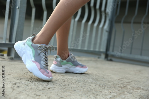 woman legs in sneakers outdoor close up