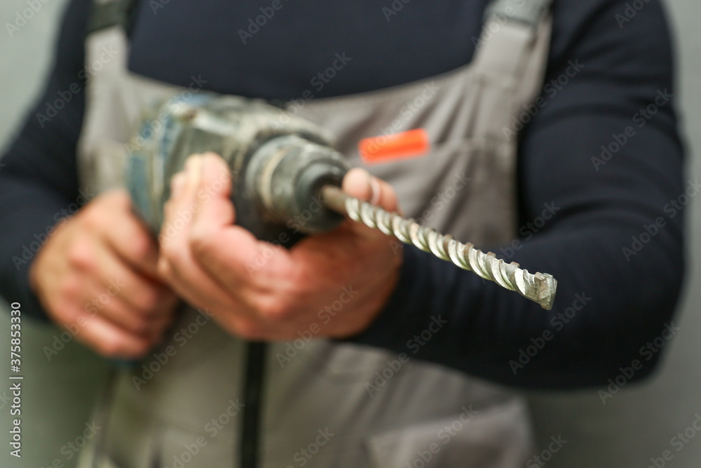 man's hand holds hammer drill man's hand holds hammer drill