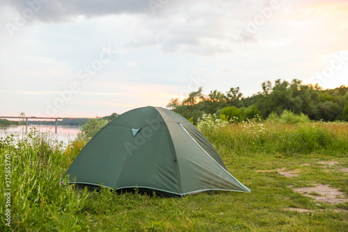 green tourist tent by the river