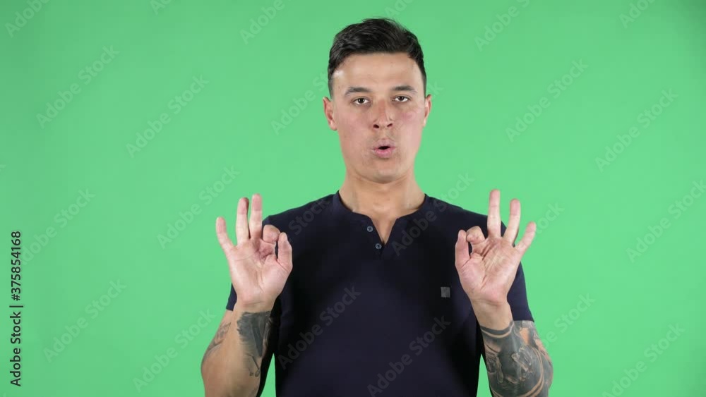 Portrait of a handsome young guy is looking at the camera relaxing and meditating. Green screen. Portrait of a handsome young guy is looking at the camera relaxing and meditating. Green screen.