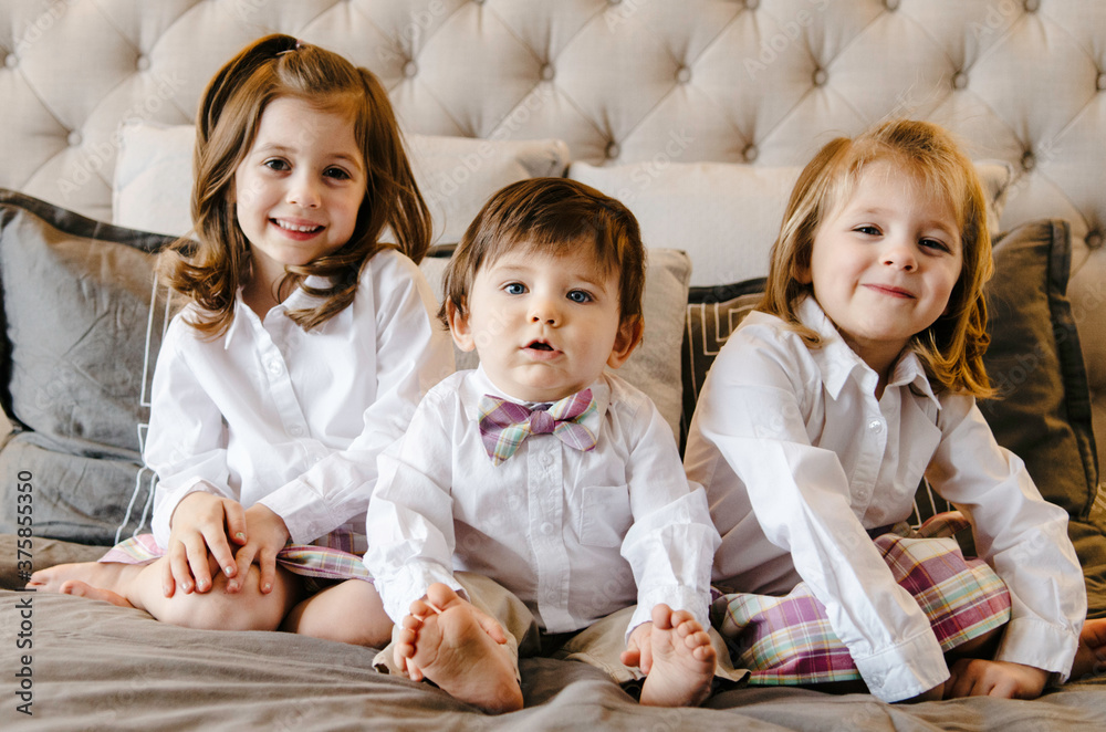 3 siblings in matching outfits, one smirking a bit 3 siblings in matching outfits, one smirking a bit