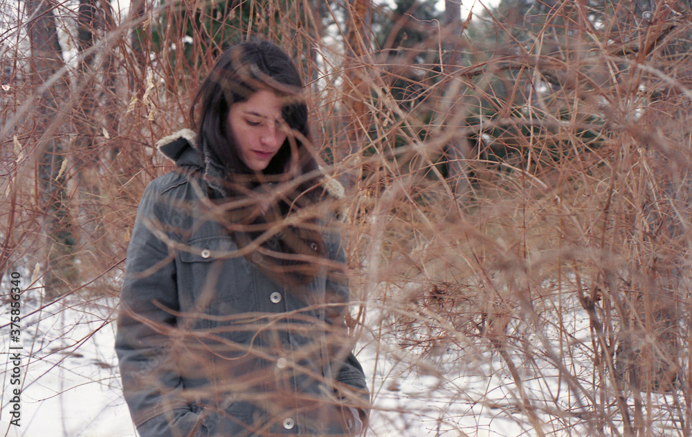Beautiful young woman behind the branches