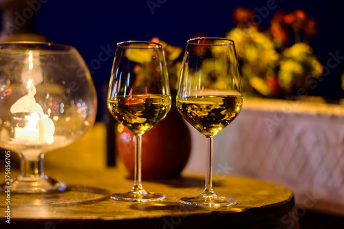 Two glasses of cold dry white wine served outdoor in cafe at night in Italy