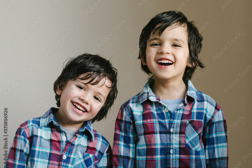 Smiling young mixed race brothers, dressed to look alike
