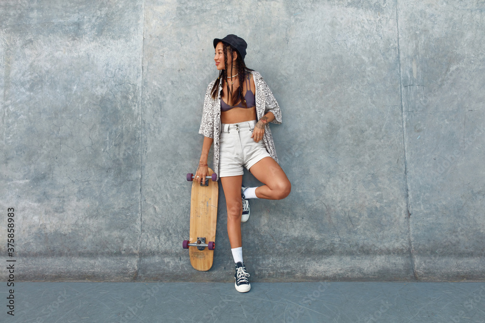 Skater Girl At Skatepark. Full-Length Portrait Of Female Hipster In Casual  Outfit With Skateboard Against Concrete Wall At Skate Park. Urban  Subculture Style And Summer Sport In City. Active Lifestyle Photos |