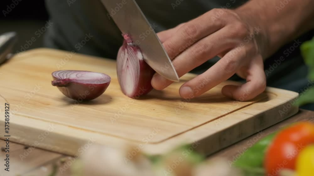 Professional chef prepares and cuts red onion. Close up slow motion Professional chef prepares and cuts red onion. Close up slow motion