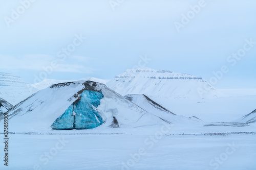 A turquoise iceberg in Spitsbergen, Svalbard. 
Winter postcard from the arctic.  photo