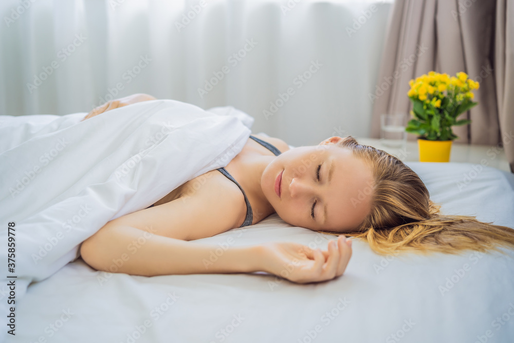 Sleep without a pillow. Young Woman Sleeping In Bed without a pillow. Portrait Of Beautiful Female Resting On Comfortable Bed without a pillow In White Bedding In Light Bedroom In Morning. People Sleep without a pillow. Young Woman Sleeping In Bed without a pillow. Portrait Of Beautiful Female Resting On Comfortable Bed without a pillow In White Bedding In Light Bedroom In Morning. People