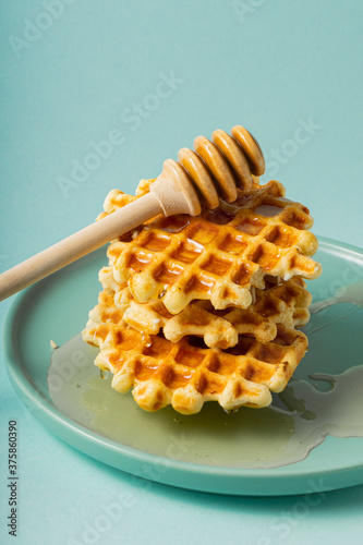 selective focus, Belgian sugar waffles with flower honey on a blue plate