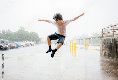 Boy dances in the rain photo