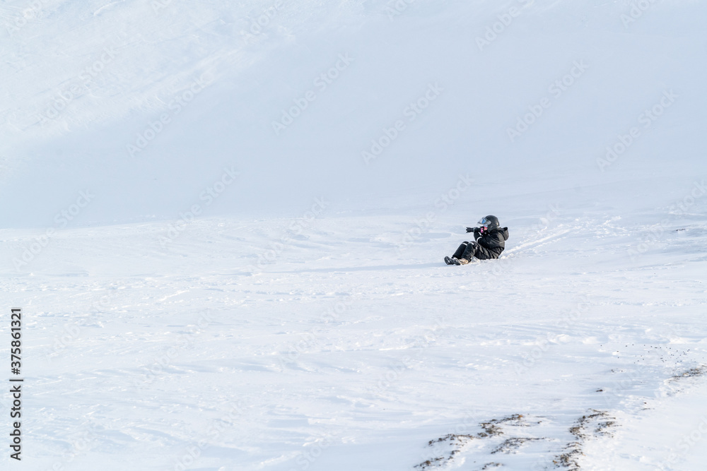 A woman slipping down the hillside on Svalbard, Spitsbergen.
Winter fun.