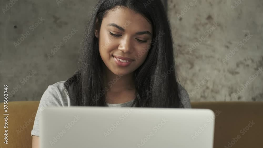 Young positive concentrated woman using laptop computer indoors at home Young positive concentrated woman using laptop computer indoors at home