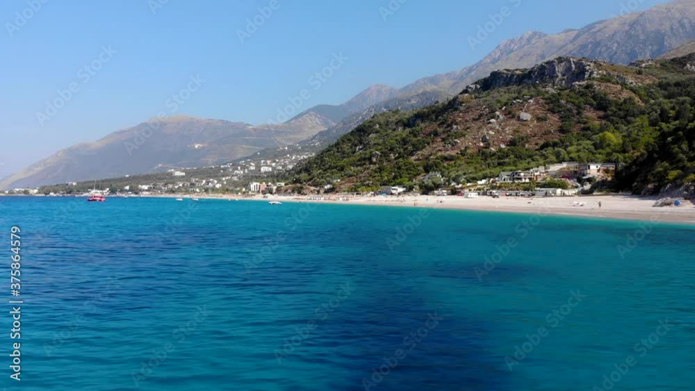 Blue azure sea water on rocky shoreline of Mediterranean with beautiful beach and mountains background Blue azure sea water on rocky shoreline of Mediterranean with beautiful beach and mountains background